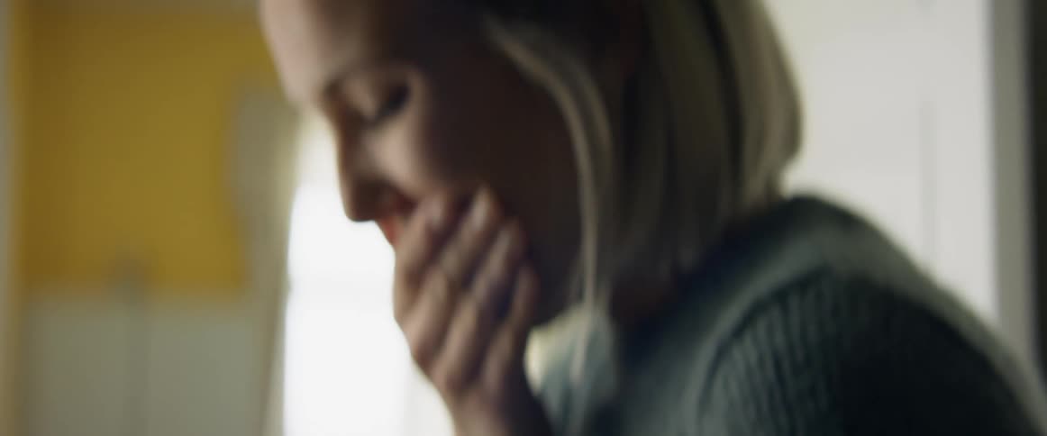 A woman looking sad and covering her face
