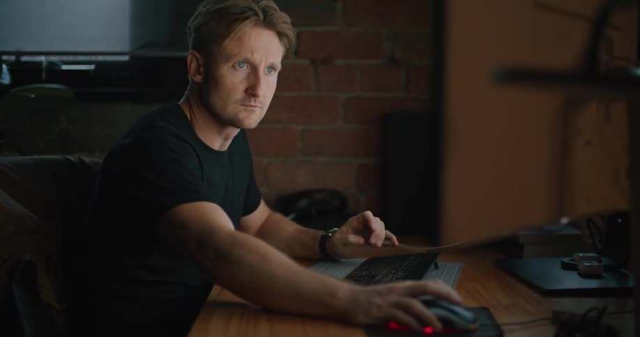 A man types on a keyboard then reaches for the mouse