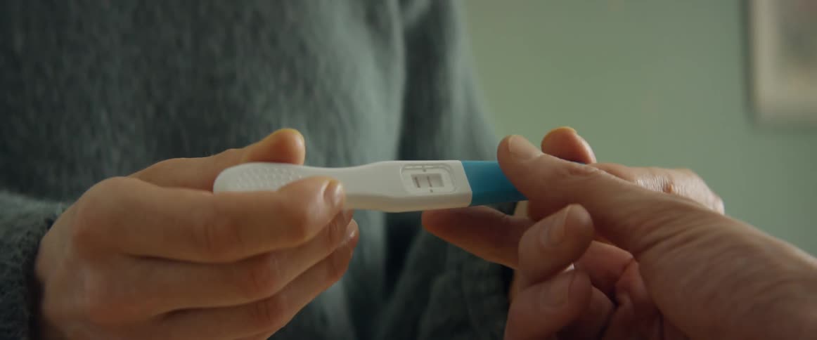 A mother showing a father a positive pregnancy test