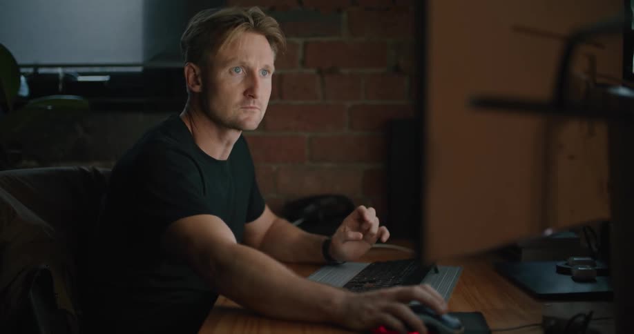 A man moves a mouse then goes back to typing on a wireless keyboard
