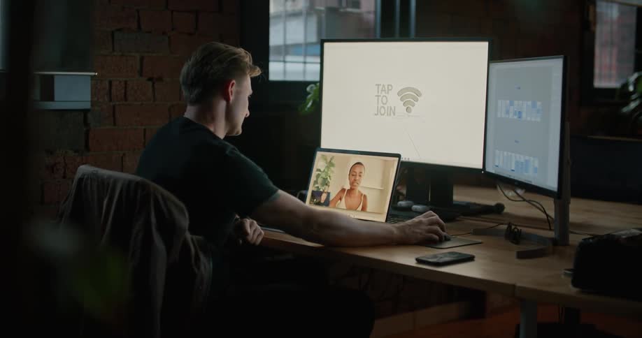 Man sitting in office in front of computer video conferences via laptop