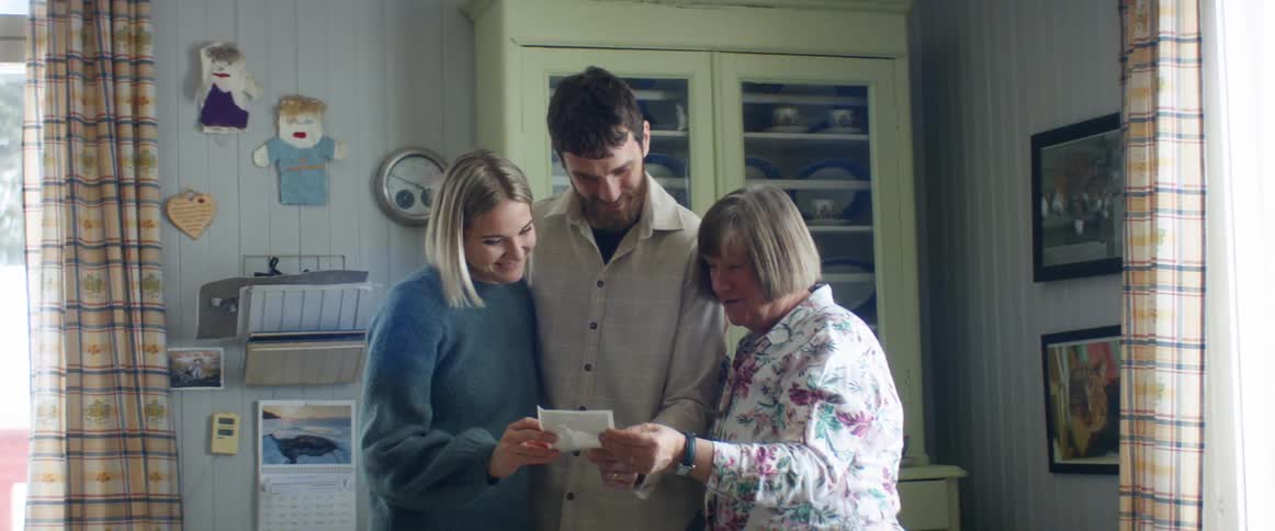 A husband and wife look at an ultrasound picture with an elderly woman