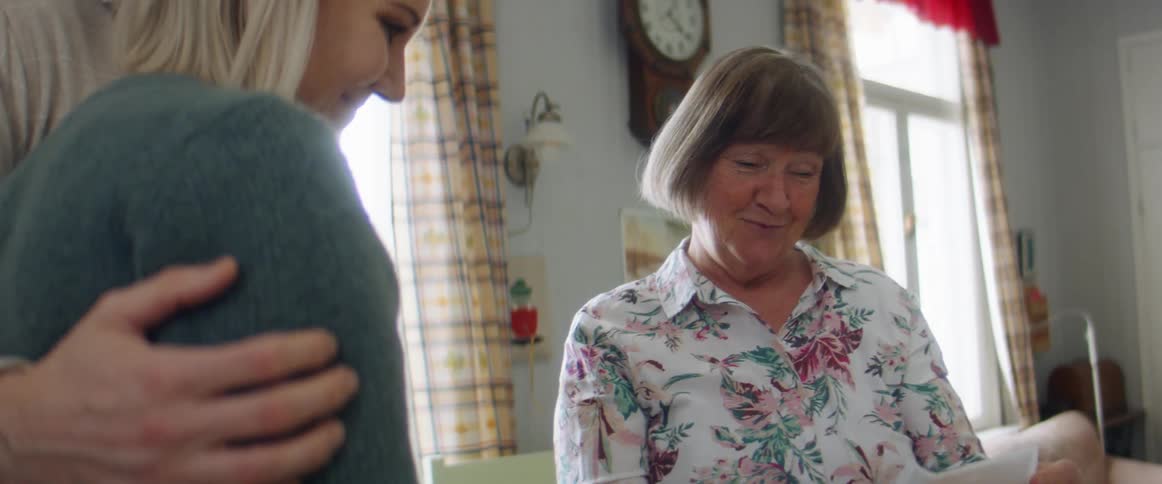 Couple share good new via picture with parent and all hug