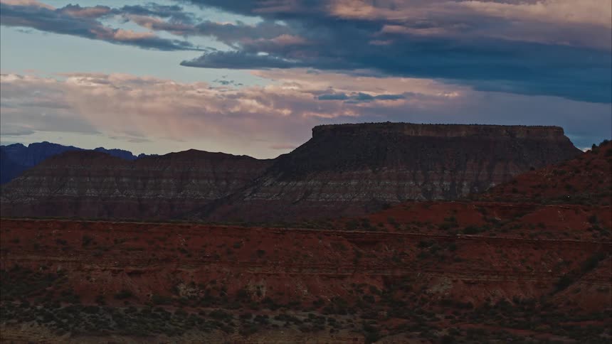 Mountains in the desert with a plateau and stormy sky and clouds in the background