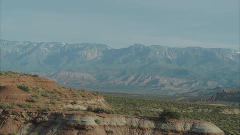 A desert mountain range is revealed across the valley over the mesas