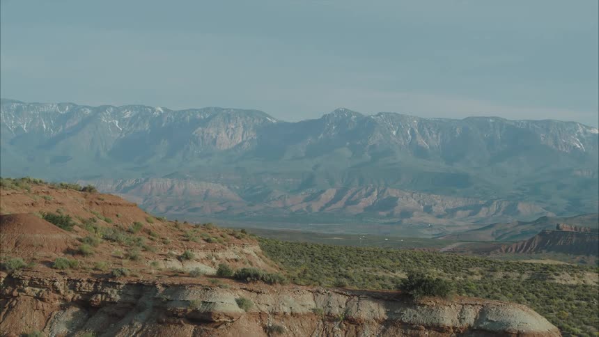 A desert mountain range is revealed across the valley over the mesas