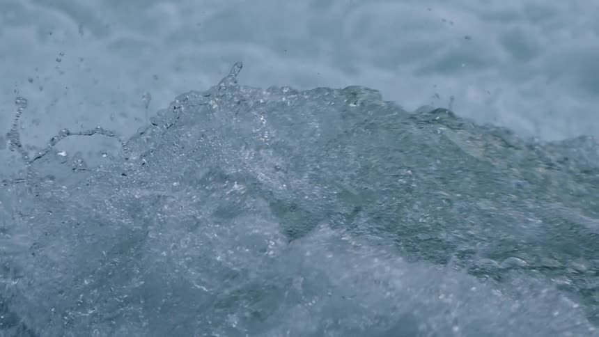 Slow motion shot looking straight downstream of clean clear water exploding straight into the air
