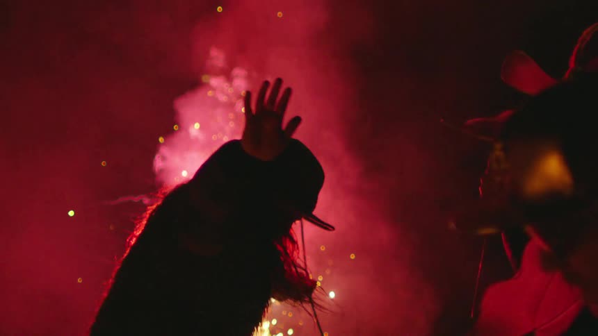 People get their groove on while dancing and celebrating as the fireworks blast all around them in this moment of absolute freedom and joy