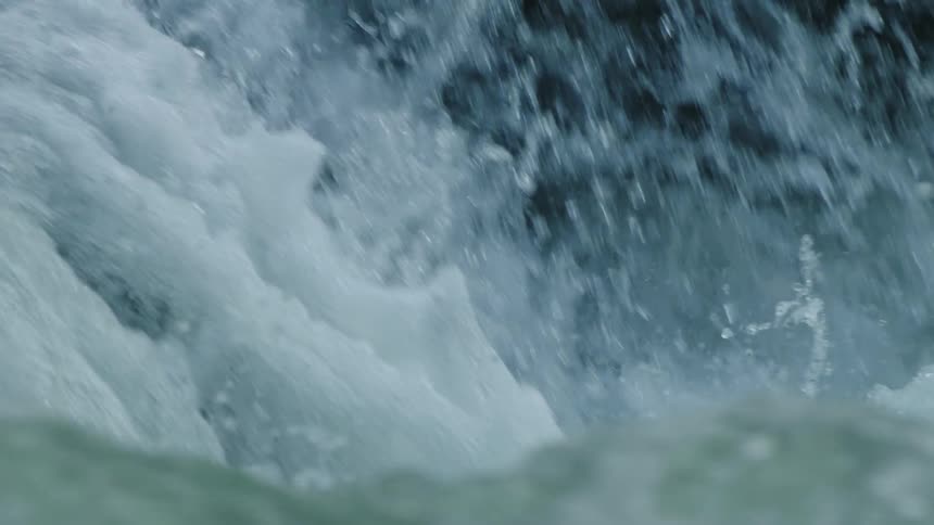 Slow motion shot of water splashing and boiling in this establishing shot of a clean clear alpine river