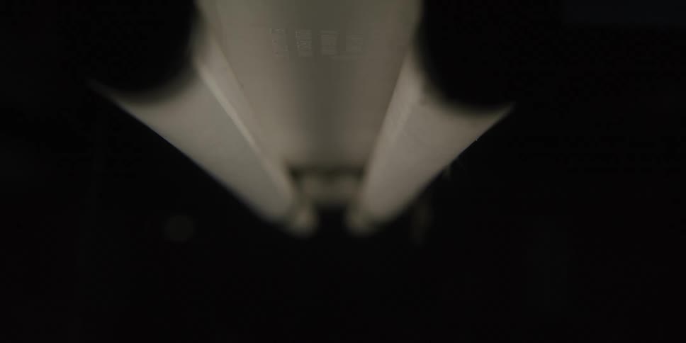 A fluorescent light bulb flickering on and off in a dark room