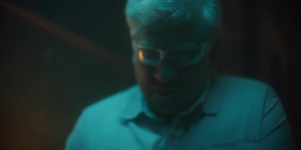 A spark flies as an elderly man looks down at what he is working on