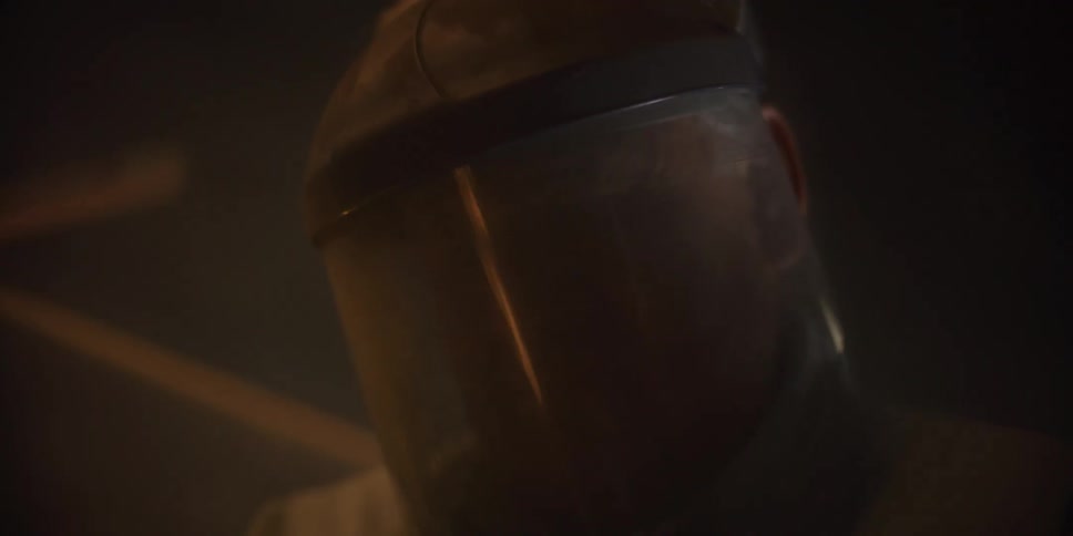 Sparks flying around a man wearing a protective face shield in a workshop