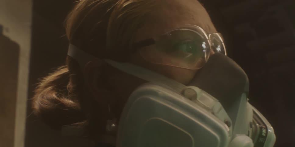 A woman wearing a ventilator mask and safety glasses