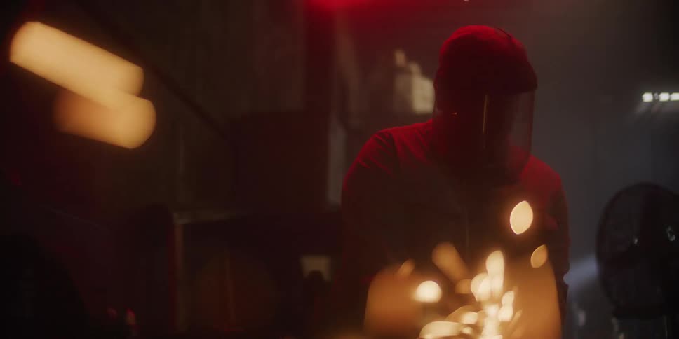 A welder wears a protective mask as sparks fly all around