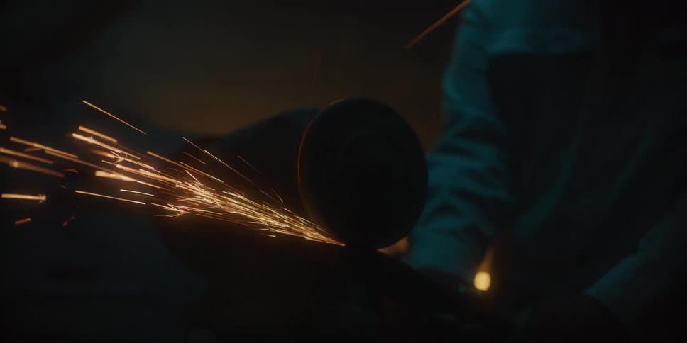 Person uses power tool creating shower of sparks
