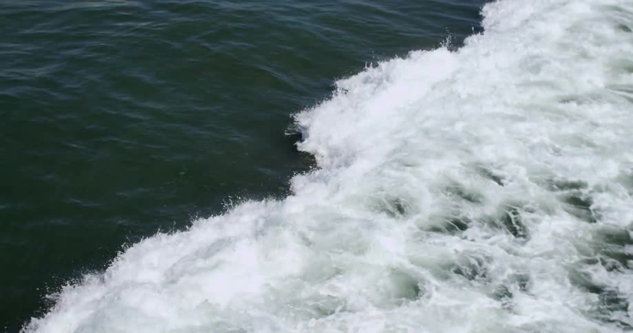 Waves crashing on a busy beach on a sunny day
