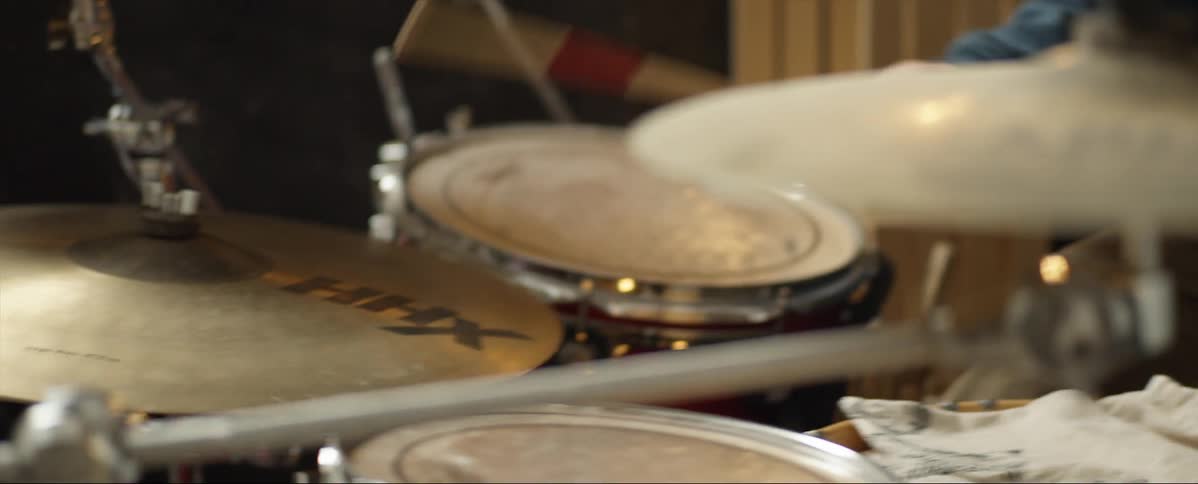 A man plays the drums in a small venue