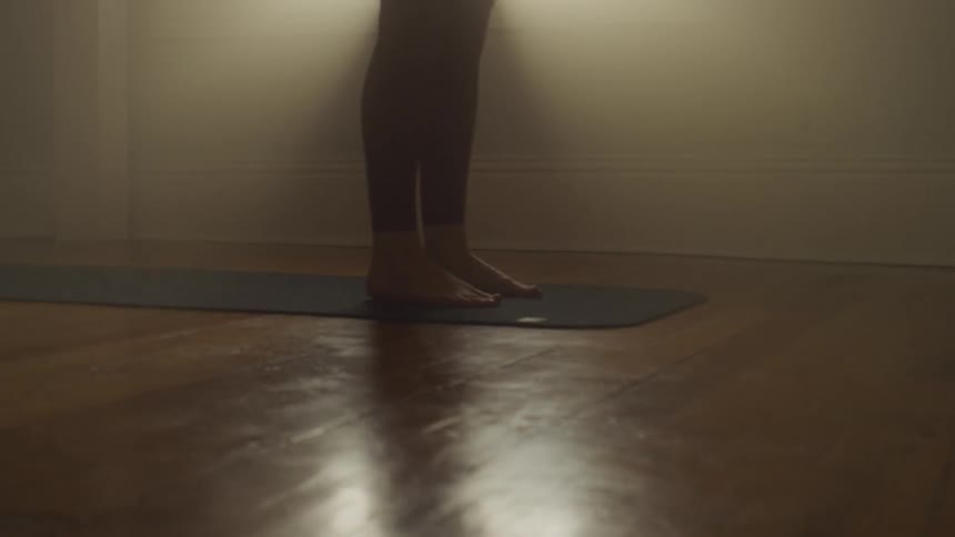 A person walking on a mat on the floor with a wall and a window in the background