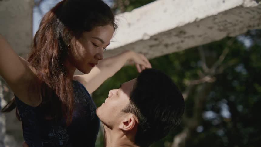 A male dancer lifting his female partner outside