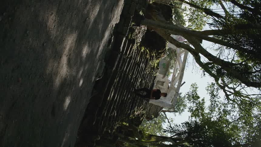 Male dancer leaps while dancing outdoors under the trees