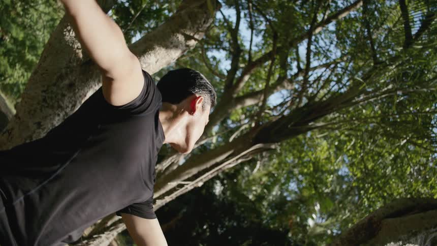 A male dancer stretching his arms outside
