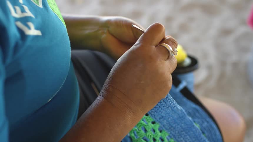 A woman with a ring crocheting with a crochet needle