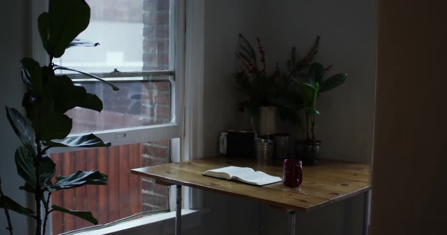 A bible sits open on a table in an apartment