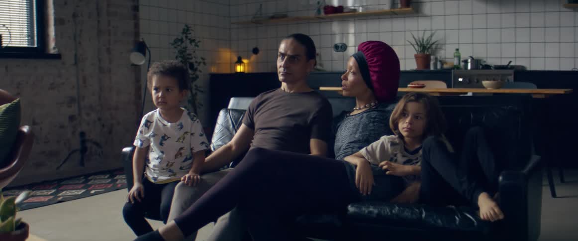 Family relaxing together sitting on the couch at home