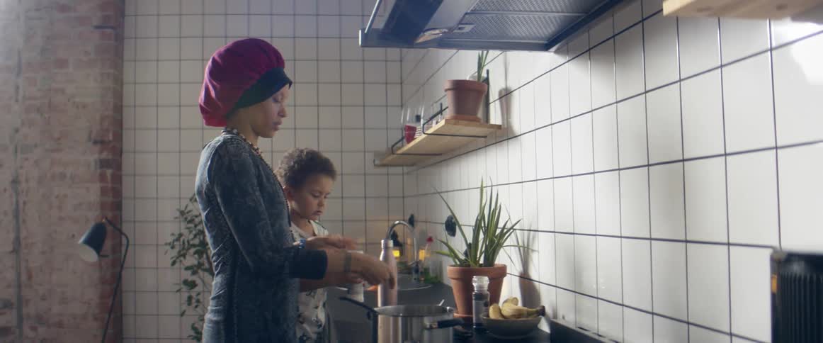 A woman and a child cooking in a kitchen