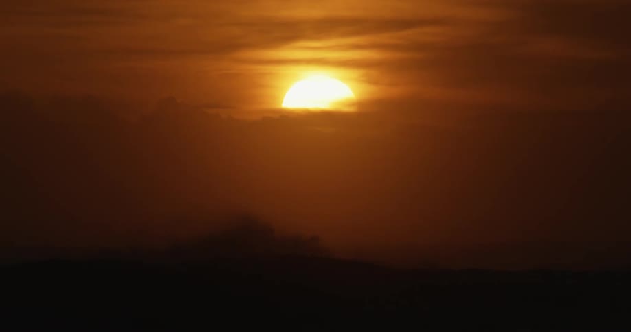 Sun rising over the ocean in a deep orange and red sky