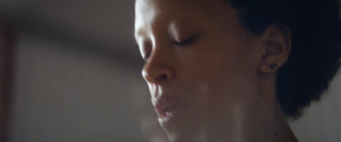 Woman stands indoors stretching
