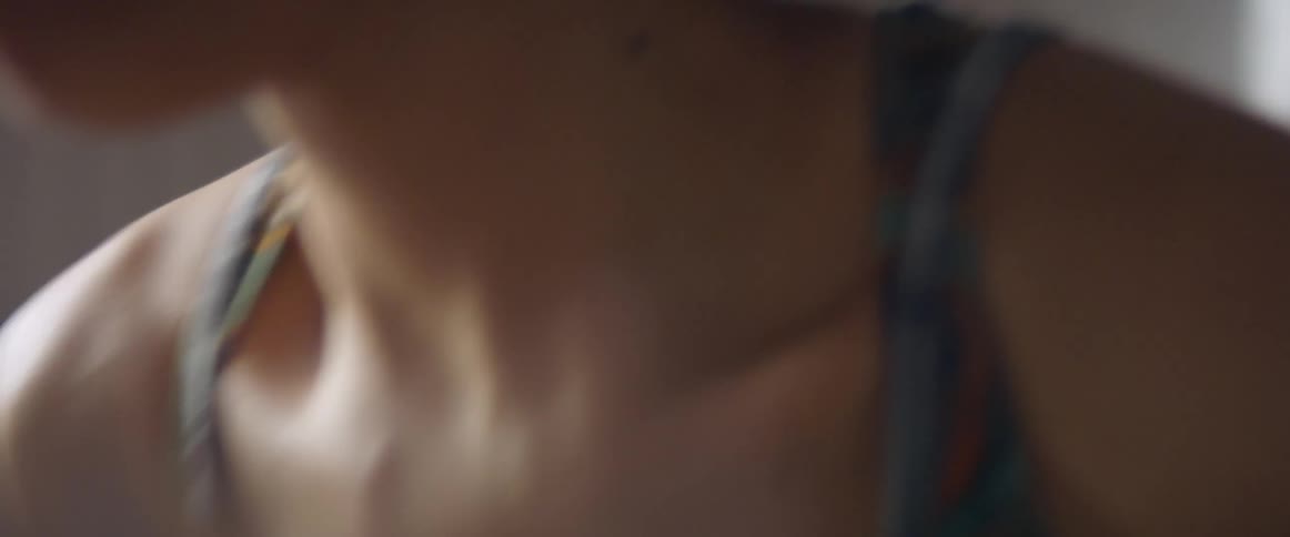 A black female from the chest up running in place in a room