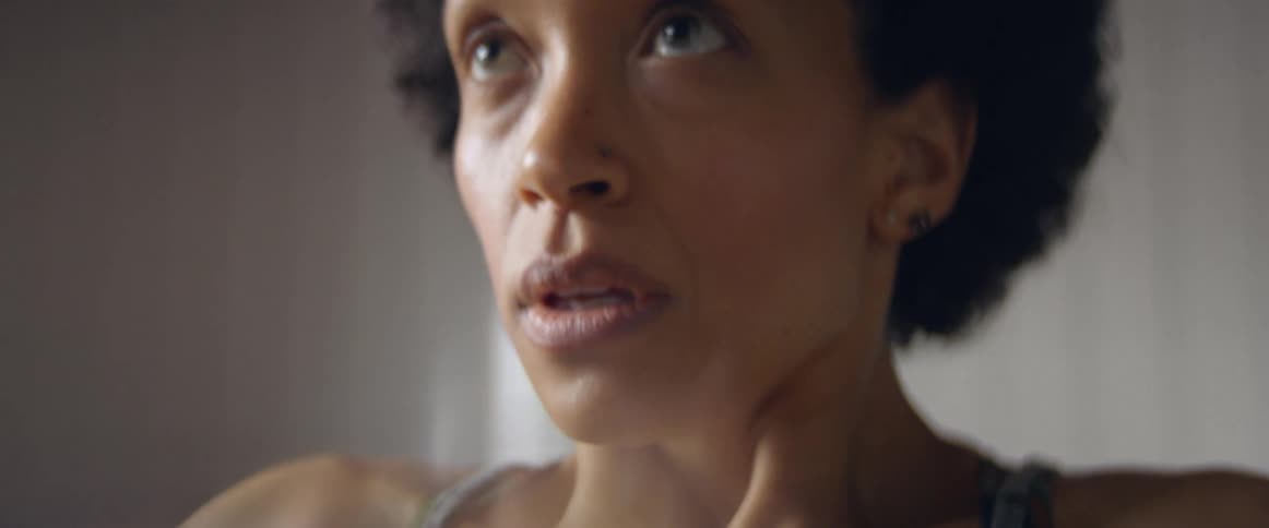 A woman catches her breath and then starts running in place as she exercises