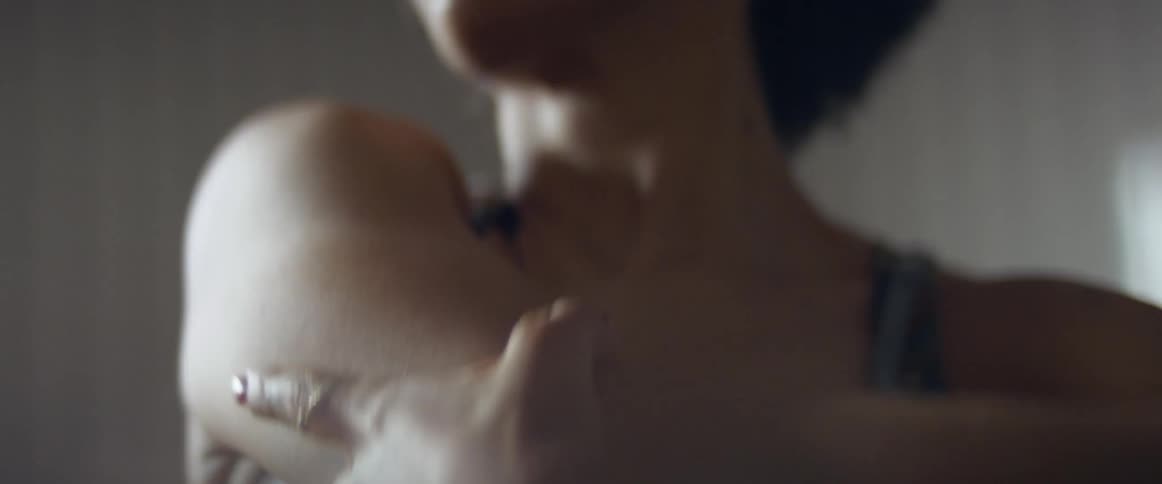 A woman with a ring in a room stretching with a wall in the background