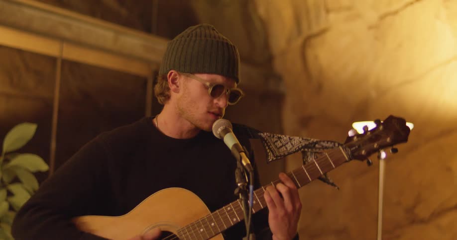 A man sings and plays the guitar