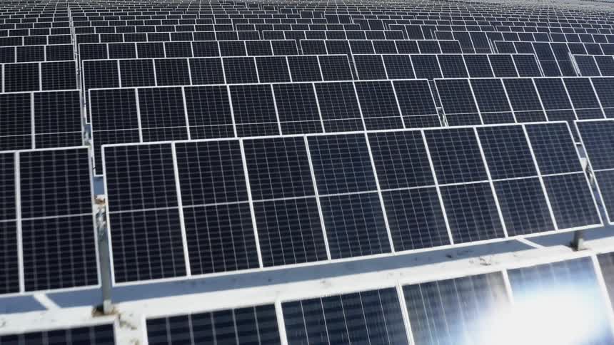 Solar farm with many solar panels and snow on the ground