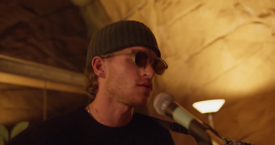 A man sings and plays the guitar