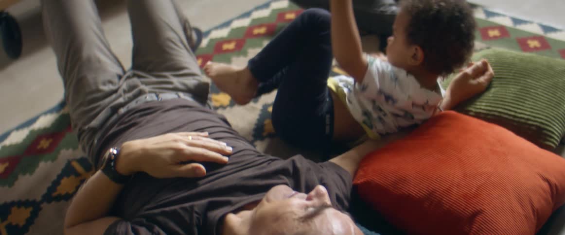 Father playing with his son and daughter on floor of the living room at home