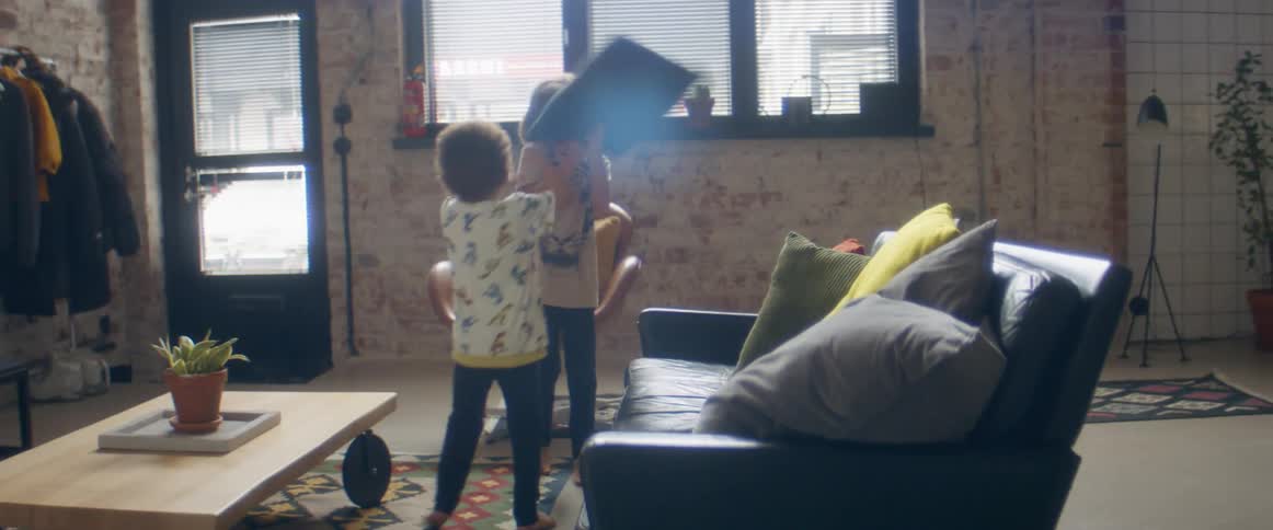 A boy and a girl in a room playing with a wall and a door in the background