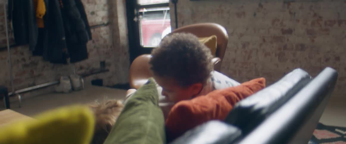 A boy and a girl in a room playing with a wall and a door in the background