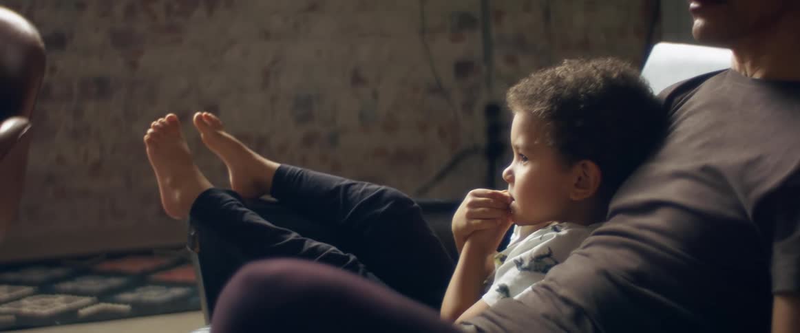 A toddler boy relaxing on a living room sofa