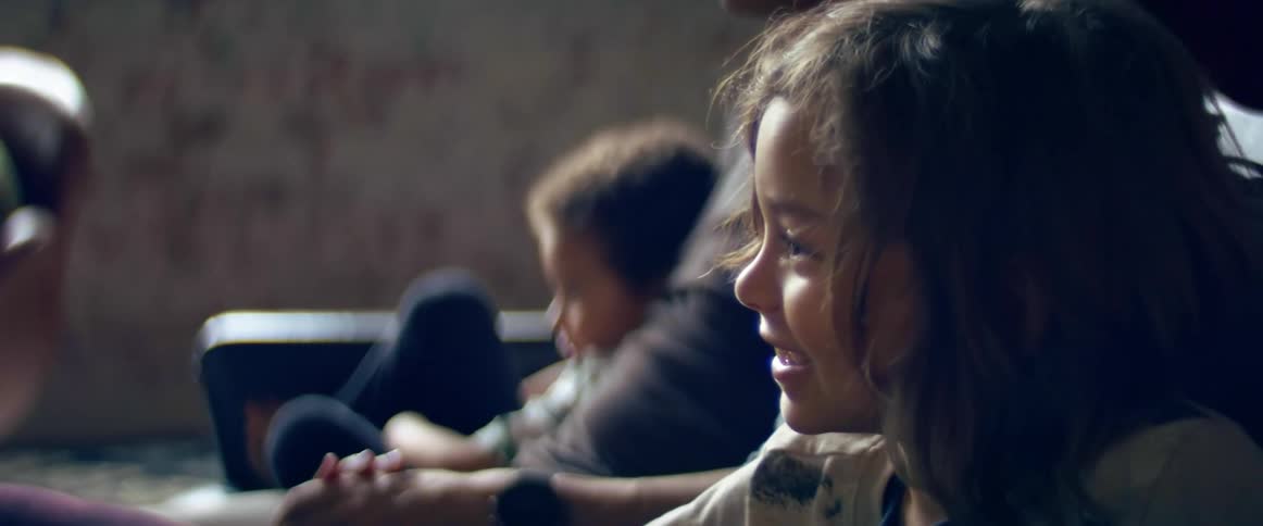 A man a woman and two boys in a room sitting on a couch