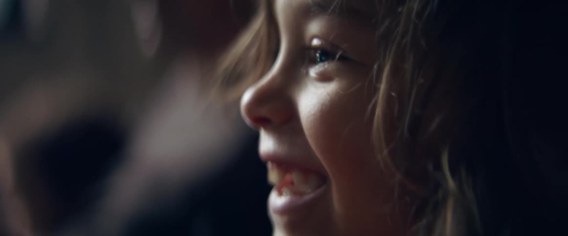 A young boy laughs as he watches television