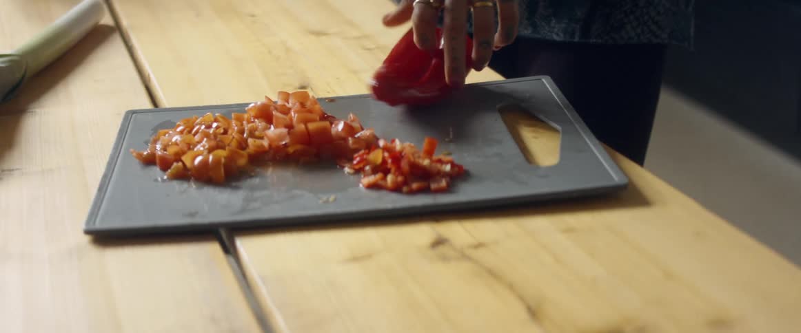 A woman dancing while chopping vegetables in a home kitchen
