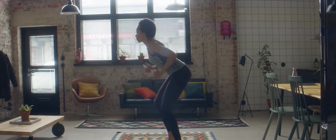 A woman sprints on the spot indoors