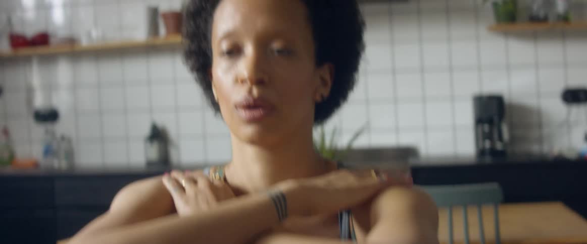 A woman is exercising in her kitchen while controlling her breathing