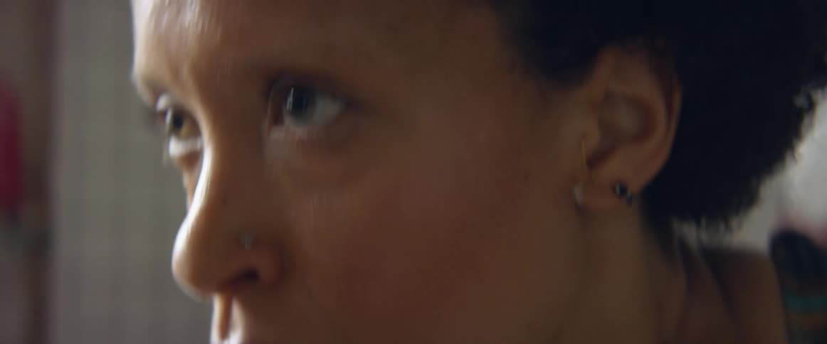 A woman exercising indoors sweating and taking deep breaths