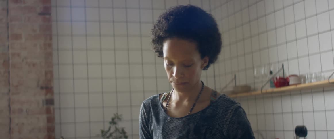 A woman listening to music and dancing in a home kitchen