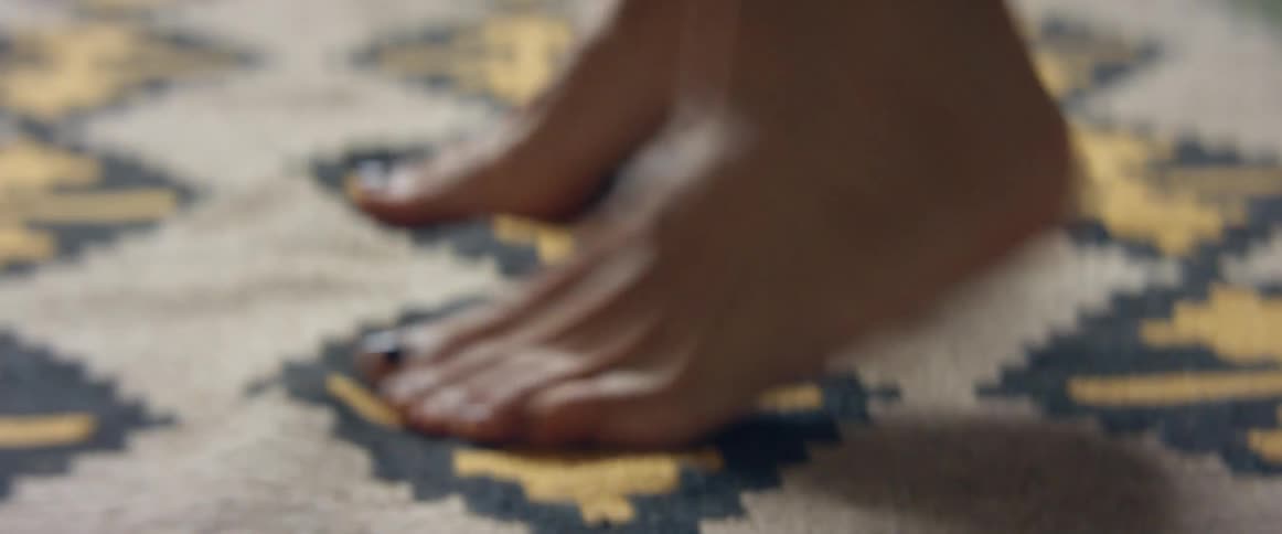 A womans feet moving fast on a rug indoors