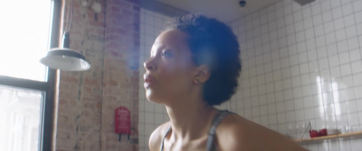 A woman exhaling while running in place during a home workout
